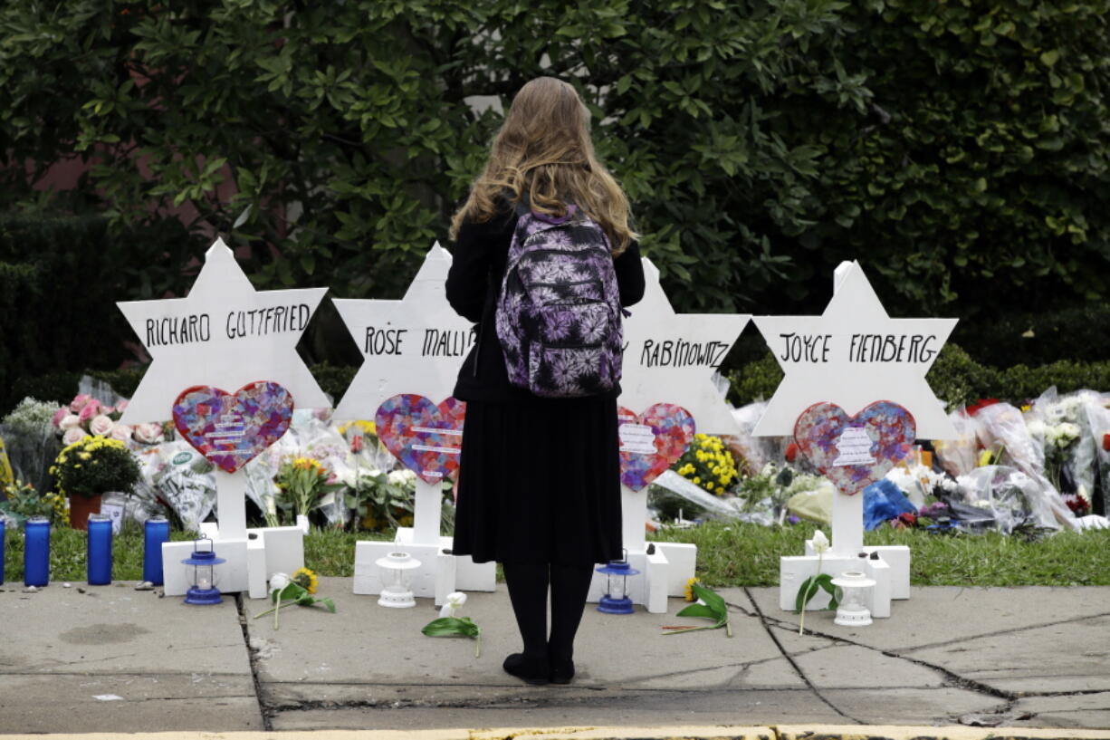 A person stands in front of Stars of David that are displayed in front of the Tree of Life Synagogue with the names of those killed in Saturday’s deadly shooting in Pittsburgh.