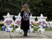 A person stands in front of Stars of David that are displayed in front of the Tree of Life Synagogue with the names of those killed in Saturday’s deadly shooting in Pittsburgh.