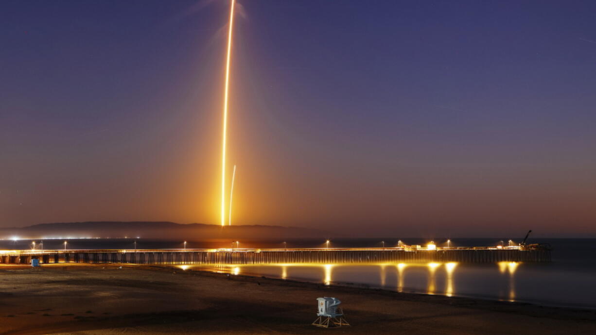 Two streaks in this long exposure photo show a SpaceX Falcon 9 rocket lifting off, left, from Vandenberg Air Force Base, as seen from Pismo Beach, Calif., on Sunday and then its first stage returning, right, to Earth at a nearby landing pad. The primary purpose of the mission was to place the SAOCOM 1A satellite into orbit, but SpaceX also wanted to expand its recovery of first stages to its launch site at the Air Force base, about 130 miles (209 kilometers) northwest of Los Angeles.