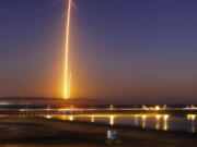 Two streaks in this long exposure photo show a SpaceX Falcon 9 rocket lifting off, left, from Vandenberg Air Force Base, as seen from Pismo Beach, Calif., on Sunday and then its first stage returning, right, to Earth at a nearby landing pad. The primary purpose of the mission was to place the SAOCOM 1A satellite into orbit, but SpaceX also wanted to expand its recovery of first stages to its launch site at the Air Force base, about 130 miles (209 kilometers) northwest of Los Angeles.