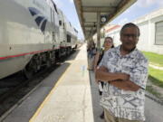 Jishnu Mukdrji and Penny Jacobs wait to board an Amtrak train Aug. 9 in Orlando, Fla. Murkdrji and Jacobs became friends from online train forums that get other rail enthusiasts together for trips around the United States. They were headed to Pennsylvania for a memorial service for one of the members in their train group who died of a heart attack in July while traveling with his train buddies to New Orleans.