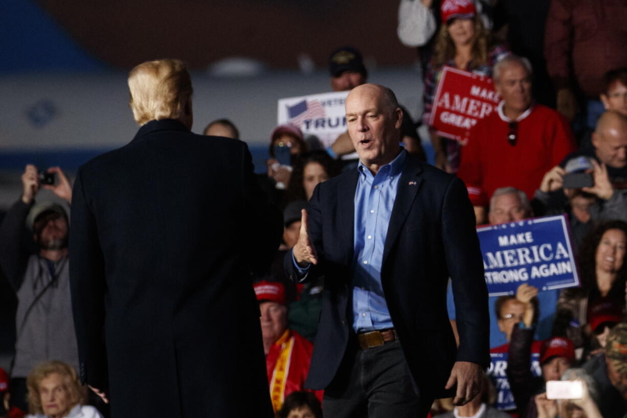 Rep. Greg Gianforte, R-Mont., is greeted on stage by President Donald Trump during a campaign rally at Minuteman Aviation Hangar, Thursday, Oct. 18, 2018, in Missoula, Mont.