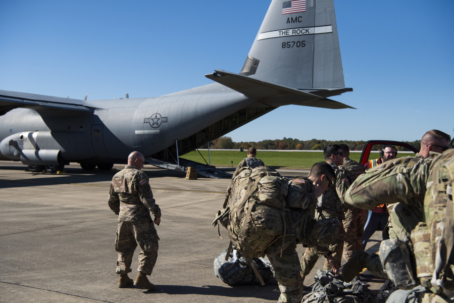 This Oct. 29, 2018 photo provided by the U.S. Air Force shows deployers from Headquarters Company, 89th Military Police Brigade, Task Force Griffin get ready to board a C-130J Super Hercules from Little Rock, Arkansas, at Fort Knox, Kentucky, in support of Operation Faithful Patriot. The Trump administration on Monday, Oct. 29, 2018, announced plans to deploy 5,200 active duty troops, double the 2,000 who are in Syria fighting the Islamic State group, to the border to help stave off the caravans. The main caravan, still in southern Mexico, was continuing to melt away, from the original 7,000 to about 4,000, as a smaller group apparently hoped to join it. (Airman 1st Class Zoe M. Wockenfuss/U.S.