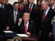 President Donald Trump holds up a pen in the East Room of the White House on Wednesday after signing bipartisan legislation to confront the opioid crisis.