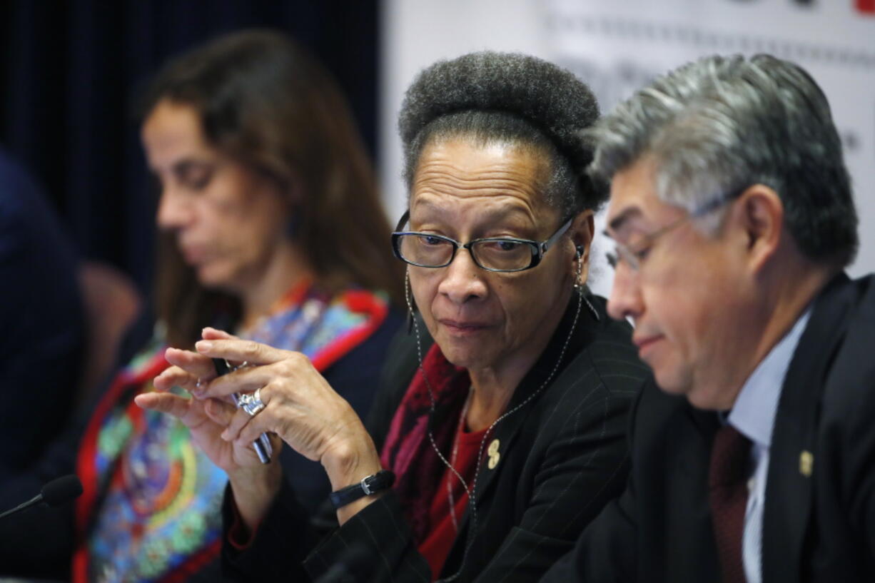 Margarette May Macaulay, center, president of the Inter-American Commission on Human Rights, confers with fellow commissioner Joel Hernandez Garcia, front, as commissioner Antonia Urrejoia, back, listens during a hearing Friday, Oct. 5, 2018, at the University of Colorado in Boulder, Colo. Human rights and advocacy groups from Latin America and U.S border states are pressing for access to an FBI DNA database to help identify the remains of hundreds of migrants reported missing along the U.S.-Mexico border.