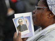 A woman holds a picture of martyred Salvadoran Archbishop Oscar Romero in St. Peter’s Square at the Vatican, Sunday.