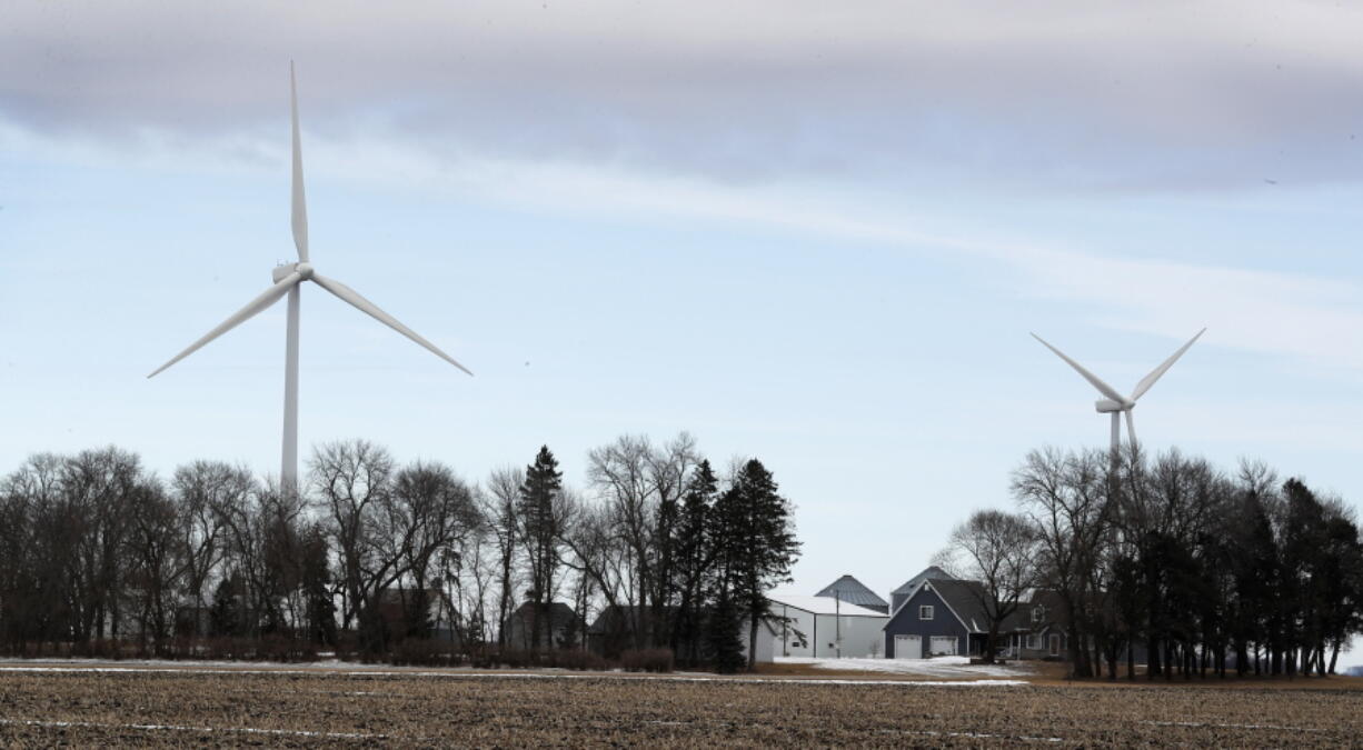 Wind turbines stand over a farmhouse near Northwood, Iowa. A new study out of Harvard finds that ramping up wind power in America would also dial up the nation’s temperatures.