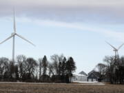 Wind turbines stand over a farmhouse near Northwood, Iowa. A new study out of Harvard finds that ramping up wind power in America would also dial up the nation’s temperatures.