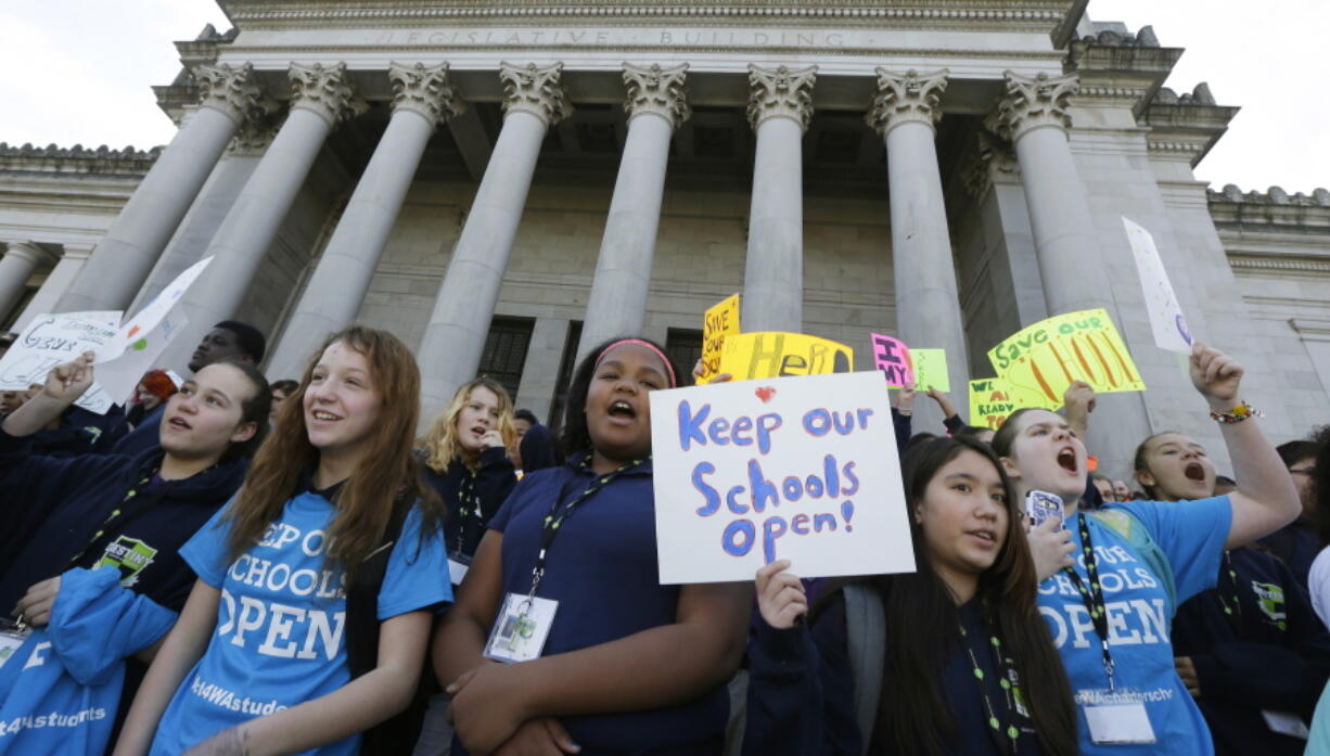 FILE - In this Feb. 25, 2016, file photo, children hold signs during a rally in support of charter schools at the Capitol in Olympia, Wash. On Thursday, Oct. 25, 2018, the Washington Supreme Court upheld most of the state’s charter school law, eliminating the specter that the classrooms serving more than 3,000 students might have to close. (AP Photo/Ted S.