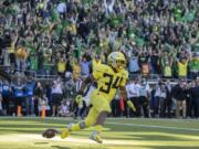 Oregon running back CJ Verdell (34), scores the winning touchdown in overtime to beat Washington 30-27 in an NCAA college football game in Eugene, Ore., Saturday, Oct. 13, 2018.