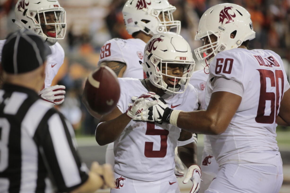 Washington State's Travell Harris (5) celebrates with teammate Andre Dillard (60) after making a touchdown during the fourth quarter of an NCAA college football against Oregon State in Corvallis, Ore., Saturday, Oct. 6, 2018. (AP Photo/Timothy J.