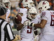 Washington State's Travell Harris (5) celebrates with teammate Andre Dillard (60) after making a touchdown during the fourth quarter of an NCAA college football against Oregon State in Corvallis, Ore., Saturday, Oct. 6, 2018. (AP Photo/Timothy J.