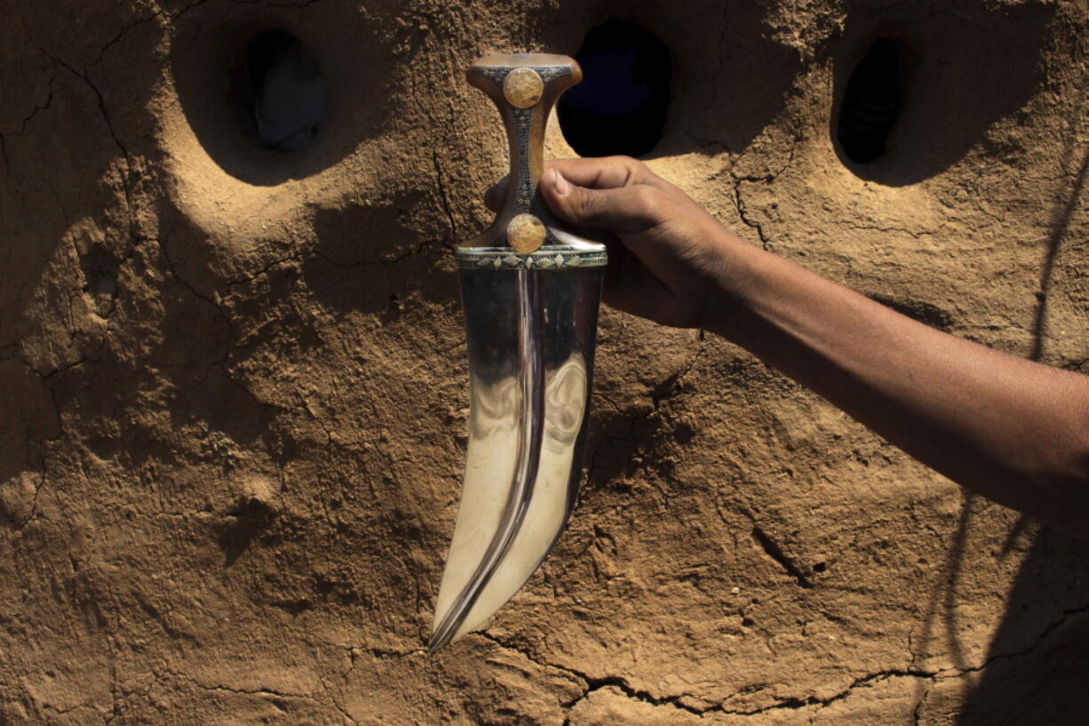 In this Oct. 6, 2018, photo, a craftsman holds a dagger or ‘Jambiyya’ in Yemeni Arabic, made out of remains of missiles, in Hajjah, Yemen. Missiles raining on Yemen from the jets of the Saudi-led coalition fighting Houthi rebels are killing thousands of civilians and militiamen alike, but amid crashing economy, some Yemenis see the bright side of it: they make daggers out of the fragments of the missiles for ordinary men traditionally wear for prestige and a show of courage.