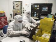 nLIGHT technicians work from computers near an optical coding machine, pictured back left, which spins strips of lasers, in the nLIGHT lab in Vancouver in October 2017.