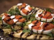 The flatbread at UnderBar is topped with caramelized onions, mozzarella cheese, arugula, tomato and a balsamic glaze.