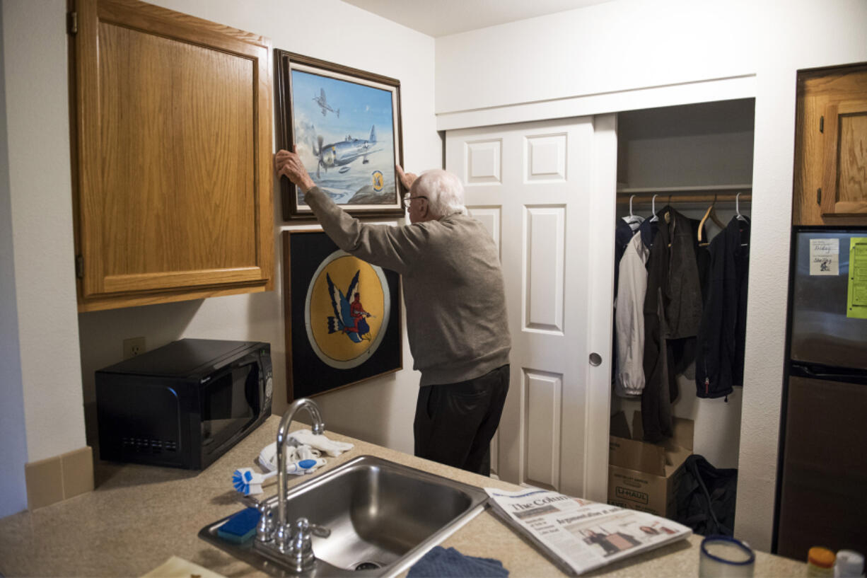 Bill Marshall rehangs a painting of the Republic P-47 Thunderbolt aircraft that he flew in World War II. The P-47 fighter-bomber was a workhorse of Allied air efforts in Europe. At top, Marshall as a young pilot.