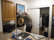 Bill Marshall rehangs a painting of the Republic P-47 Thunderbolt aircraft that he flew in World War II. The P-47 fighter-bomber was a workhorse of Allied air efforts in Europe. At top, Marshall as a young pilot.