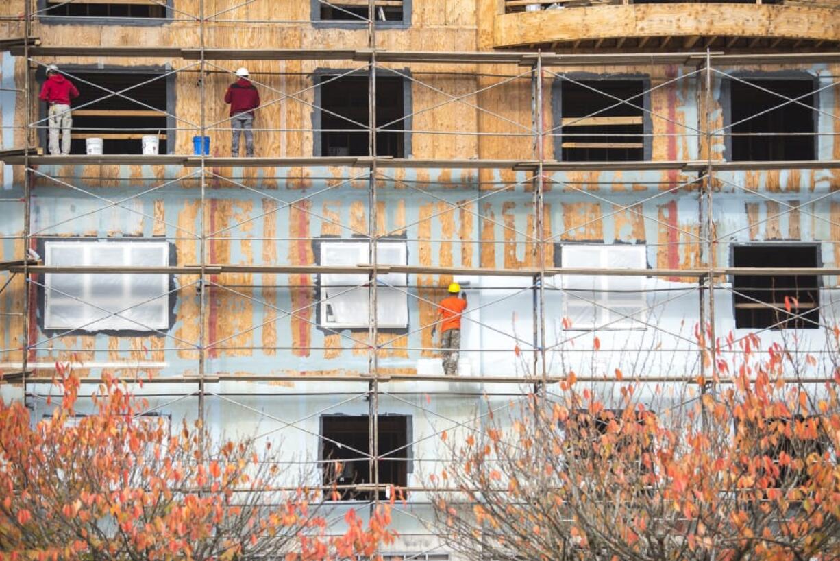 Construction crews work on Our Heros Place at the corner of D Street and East 13th Street in late October. Construction has added jobs steadily throughout this year.