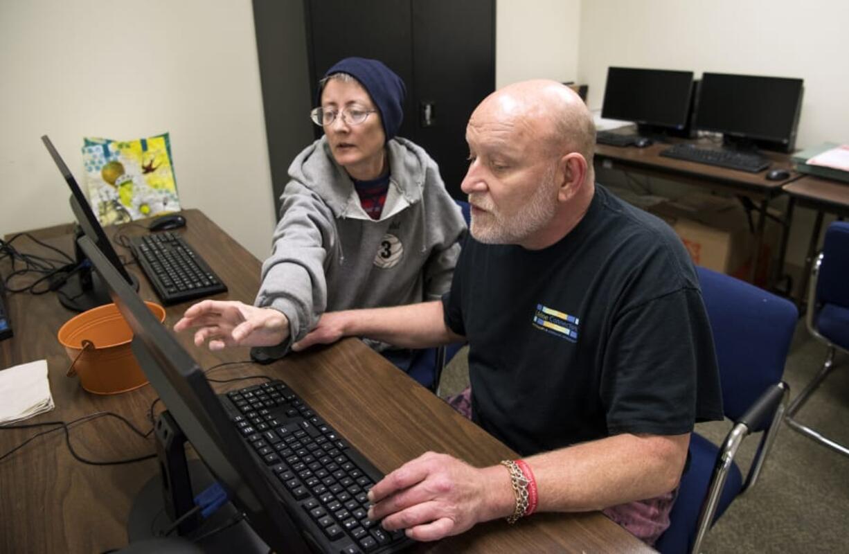 Sheri Hoff describes her plan as Keith Wells, both of Vancouver, helps her put together a pamphlet with all of the resource class times for the Recovery Resource Center in Vancouver. Wells is an AmeriCorps VISTA member, and he manages the center.