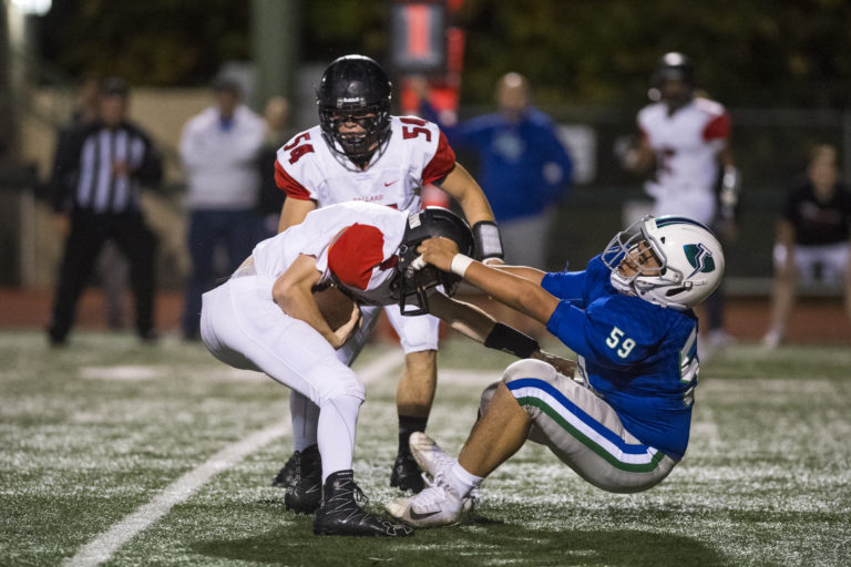 Mountain View's Thai Hindman tries to pull down Ballard quarterback Ryan Blokker during a game at McKenzie Stadium Friday night, Nov. 2, 2018.