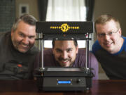 Lorin Mueller, electrical engineer, from left, Chase Harper, supply chain and marketing manager, and Jesse Howard, mechanical engineer, show their prototype desktop thermoformer Friday morning.