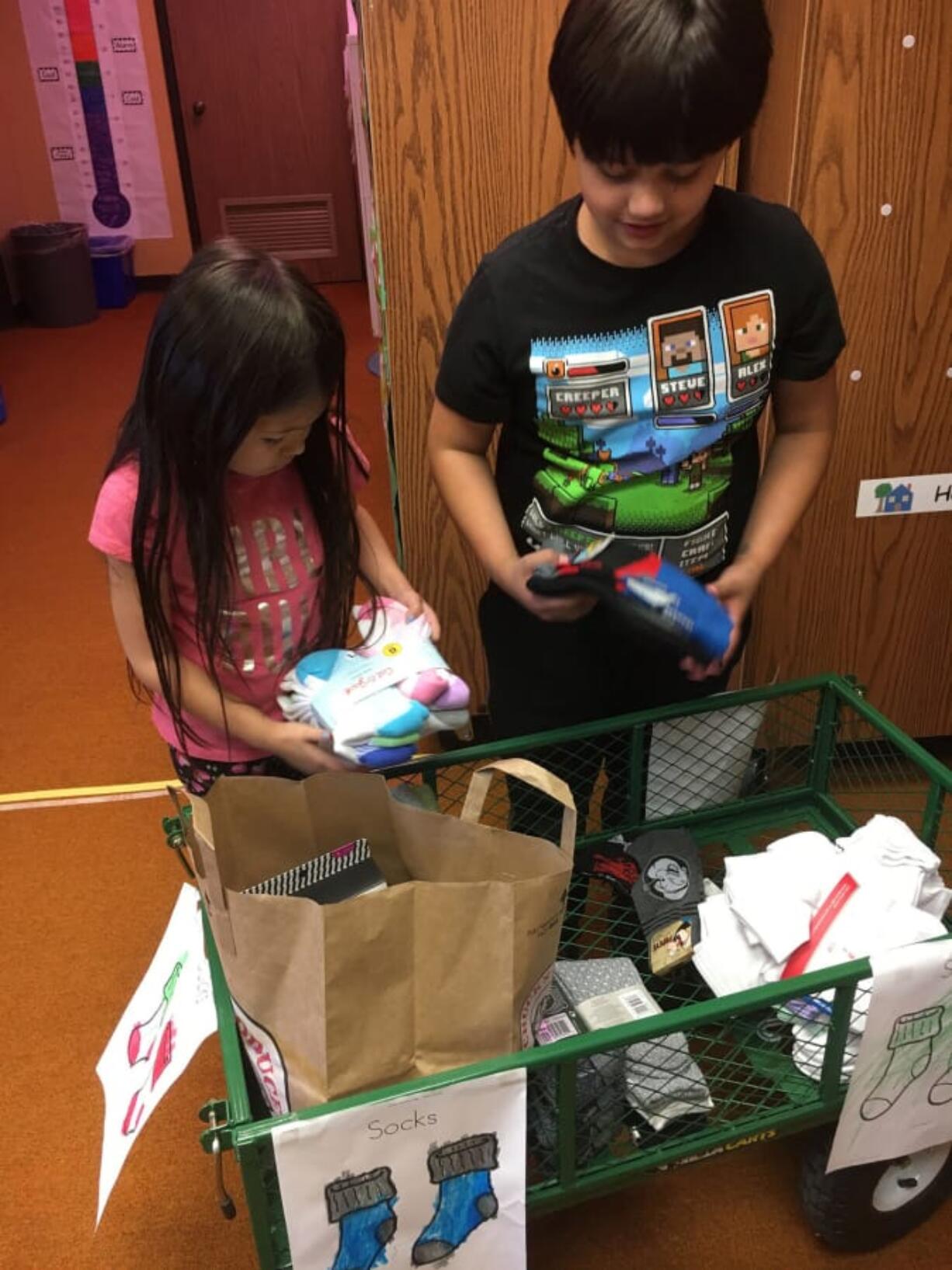 Ridgefield: Union Ridge Elementary School students Savanhy Virakitti, left, and Bruce Kizim sort through donations for their Socktober drive, in which students collected socks to donate to the Council for the Homeless in Vancouver.