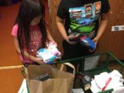 Ridgefield: Union Ridge Elementary School students Savanhy Virakitti, left, and Bruce Kizim sort through donations for their Socktober drive, in which students collected socks to donate to the Council for the Homeless in Vancouver.