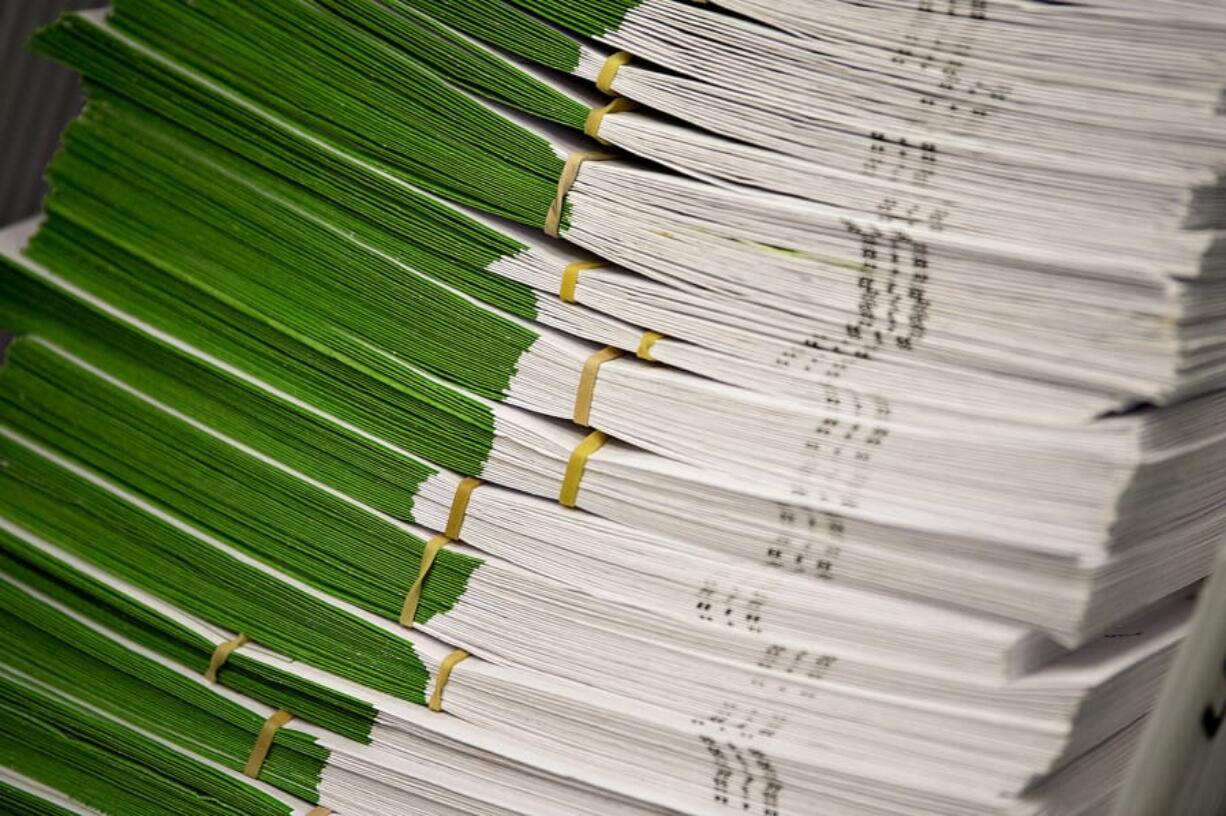 Stacks of ballots wait to be inspected by officials at the Clark County Elections Office in 2018.