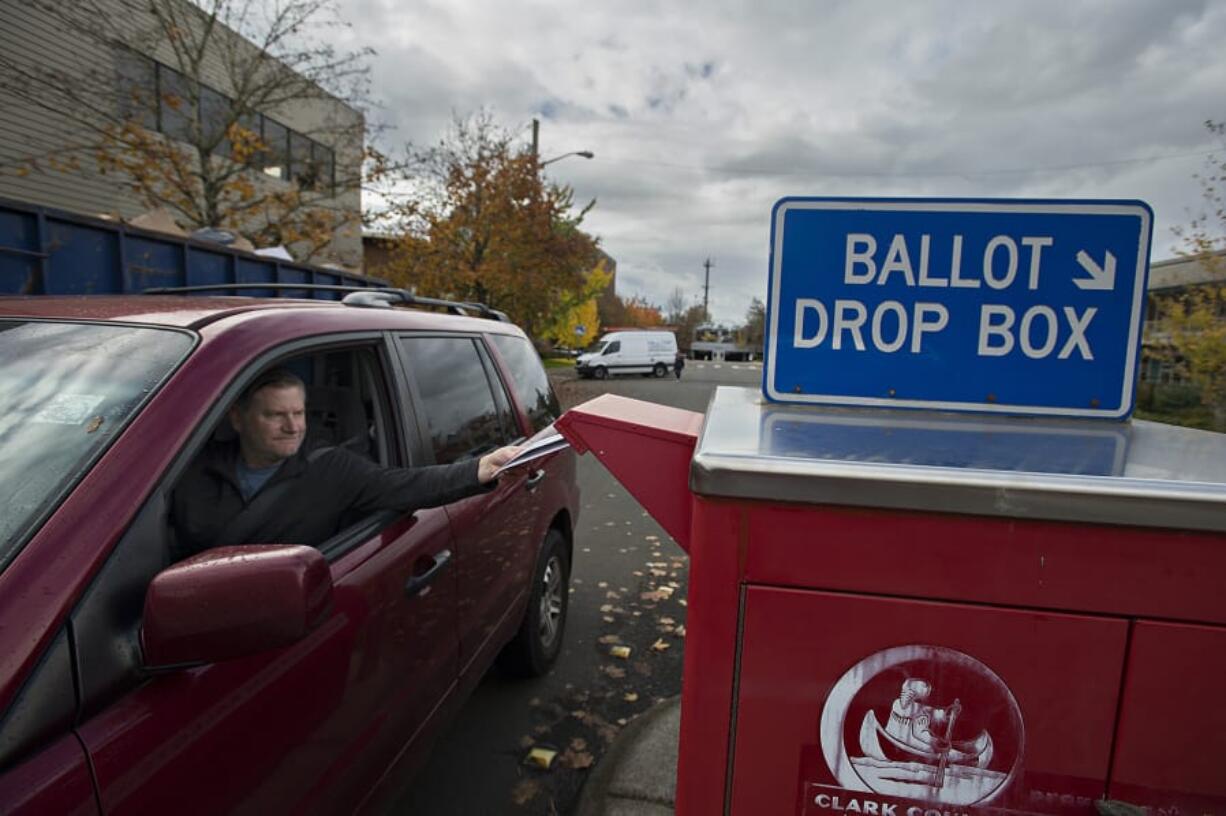 Dave Perlick of Vancouver drops his family’s ballots into the downtown ballot box Monday. Ballots need to be deposited by 8 p.m. today to be valid.