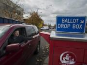 Dave Perlick of Vancouver drops his family’s ballots into the downtown ballot box Monday. Ballots need to be deposited by 8 p.m. today to be valid.