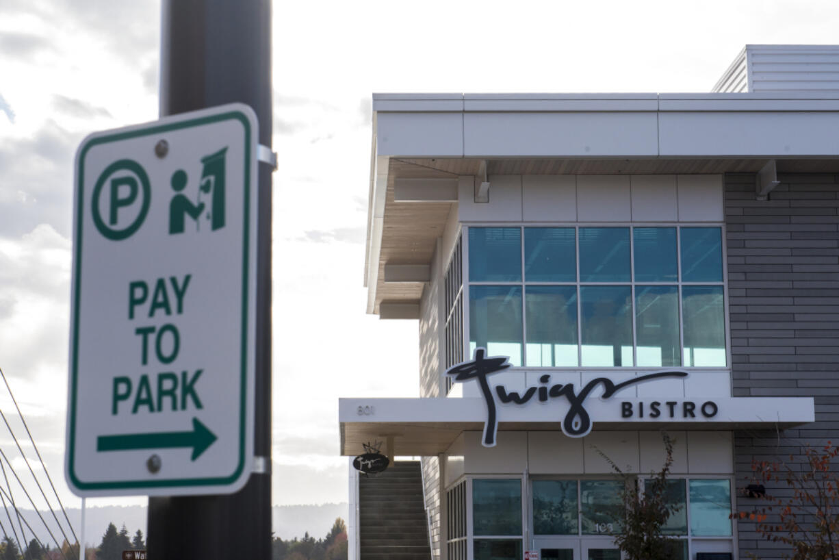 A sign notifying drivers they need to pay to park is seen in front of Twigs Bistro on Tuesday.