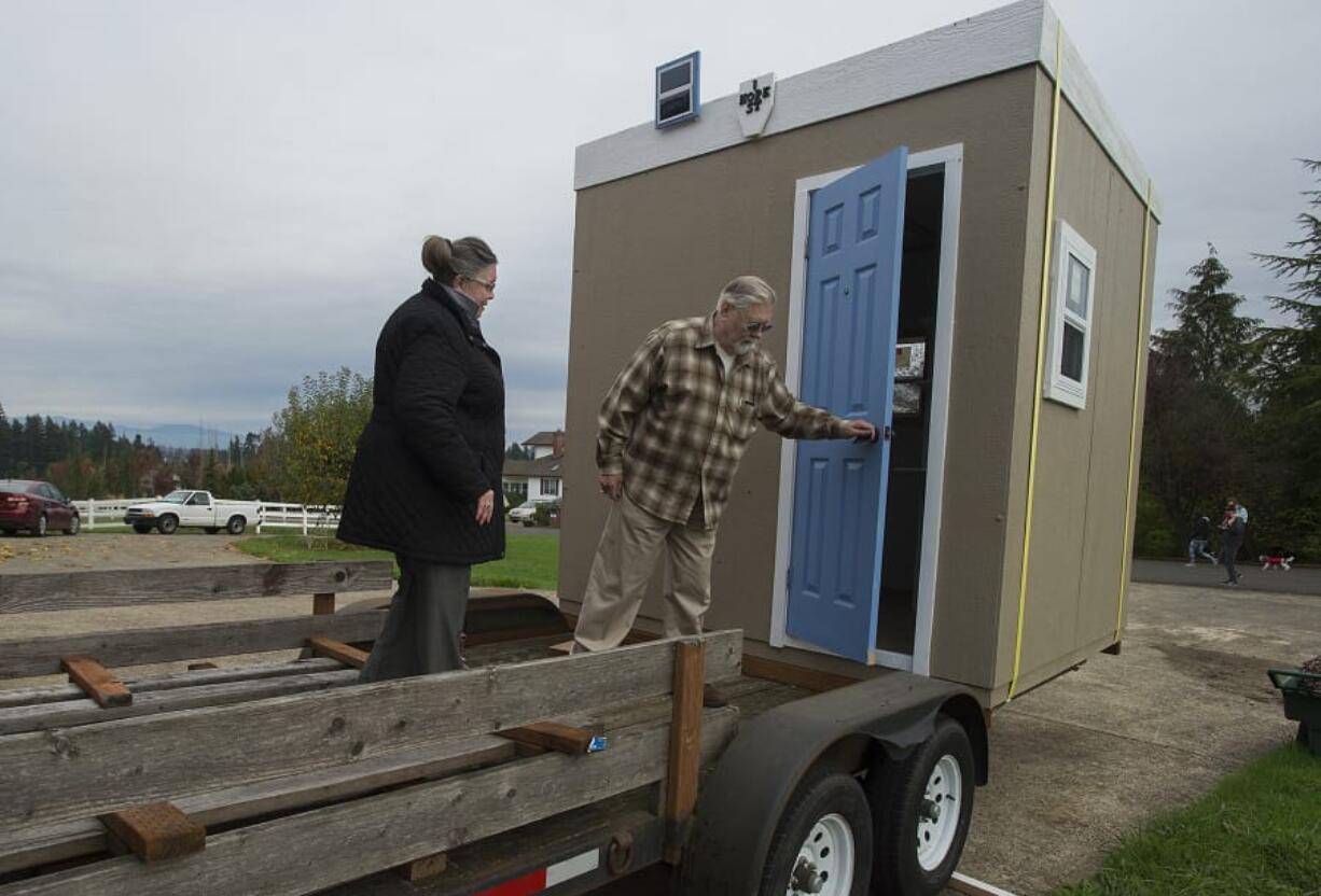 Jeannie Hix and her husband, entrepreneur Steve Hix, prepare to enter one of the Dwellings of Hope in Ridgefield on Friday afternoon.