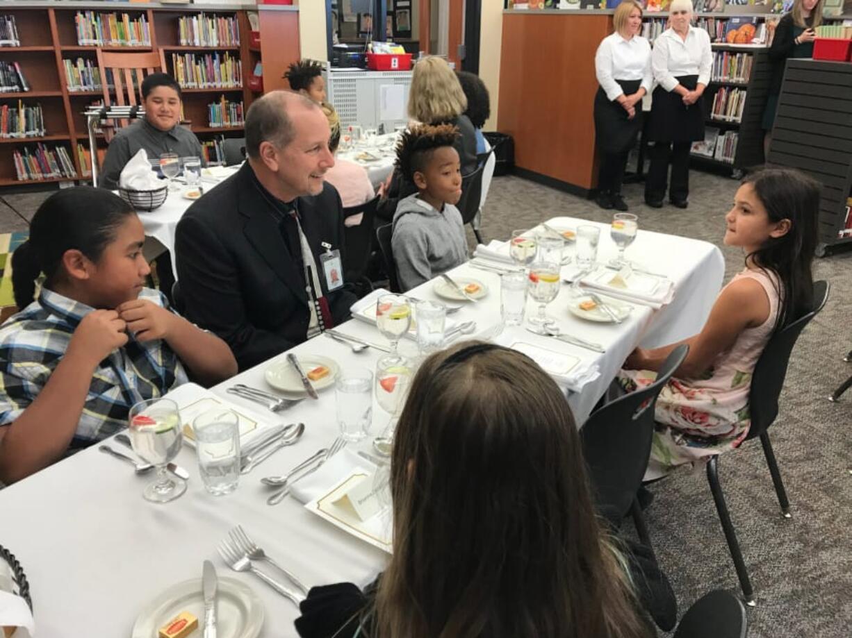 East Vancouver: Evergreen Public Schools Superintendent John Steach sits with students during a lesson in fine dining, where students learned table manners and shared a four-course meal with district leaders and community members.