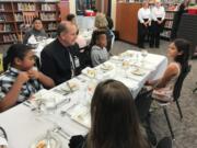 East Vancouver: Evergreen Public Schools Superintendent John Steach sits with students during a lesson in fine dining, where students learned table manners and shared a four-course meal with district leaders and community members.