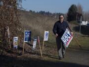 Eric Holt, who campaigned for Clark County Council chair, collects his signs after the election along Southeast Columbia Way in Vancouver on Thursday afternoon.