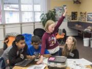 Fifth-graders Dean-Anthony Elesha, from left, Sebastian Herrera Cruz, Chasity Cherrington and Lily Podboy ask for help while working on a history-themed puzzle box earlier this month at Sifton Elementary School. Students used a series of puzzles to find the solutions to a variety of combination locks.