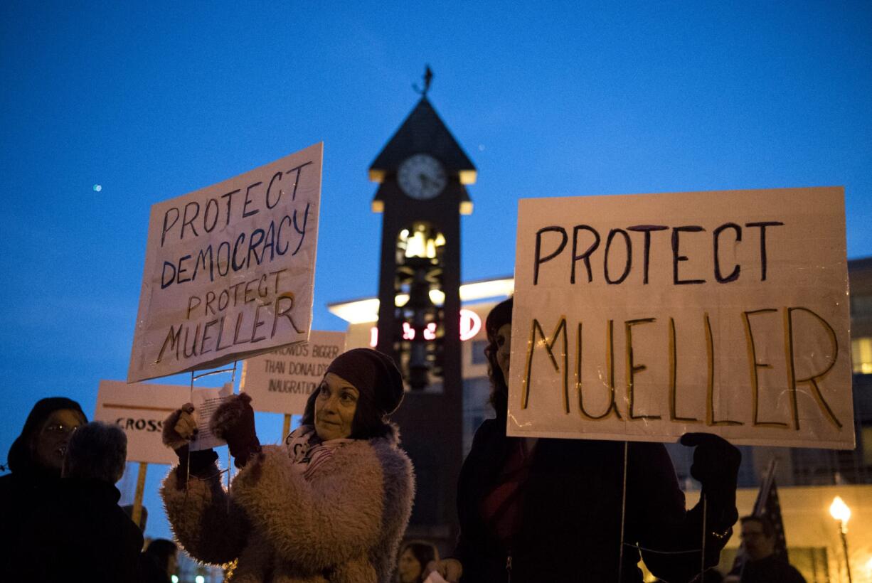 Debra Samuel, left, and Connie Hewitt, right, both of Vancouver, hold up signs as they gather at Esther Short Park for the "Nobody is Above the Law" rally on Thursday, Nov. 8, 2018. The nationwide rallies and marches are protesting the implications of President Donald Trump's dismissal of Attorney General Jeff Sessions and its potential effect on the Mueller investigation into Russia meddling in the 2016 election.