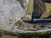 Sediment backs up behind the dam as water flows over the spillway in the bottom left-hand corner of the photo. The Army Corps of Engineers wants to raise the spillway up to 23 feet in future years. (Adam Mosbrucker/U.S.