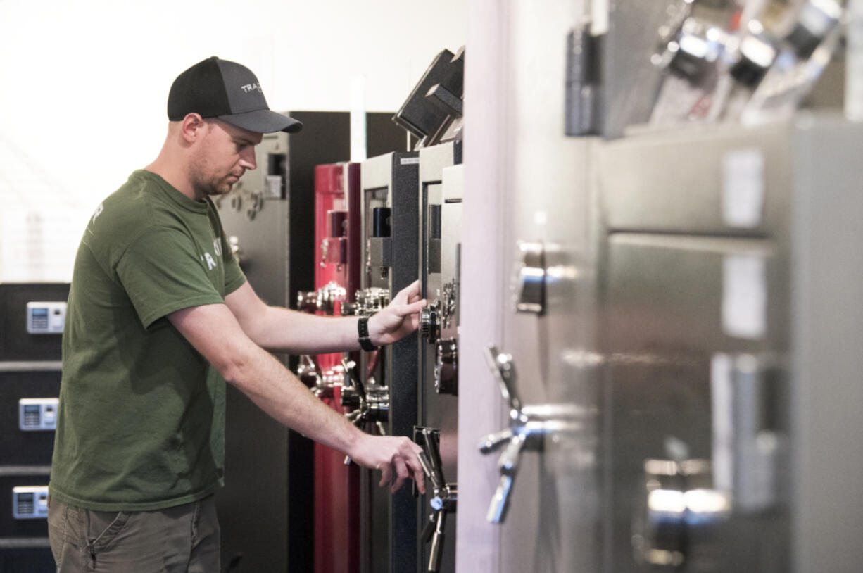 Tracker Safe co-owner Luke Boyer of Vancouver displays one of the popular American Security brand safes at the Tracker Safe shop in Vancouver on Wednesday. Boyer said he noticed an uptick in customers last week after I-1639 passed, tightening laws surrounding safe gun storage.