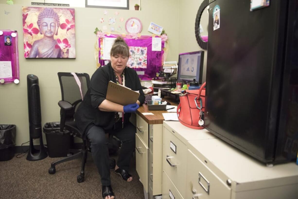 Ronda J. Harrison, care navigator at the Veterans Affairs Rapid Response Clinic in Vancouver, checks a patient’s chart.