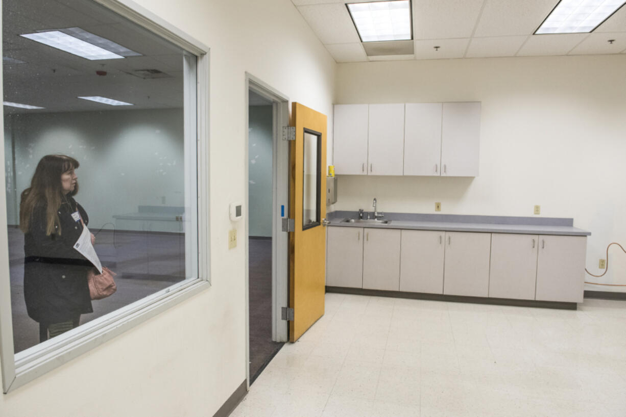 Carol Rochat looks through a window into an unfinished room while touring the Vancouver Navigation Center on Grand Boulevard in Vancouver. The day center takes up about 5,000 square feet and the remaining unused space in the large building could be occupied in the future by other service providers.