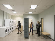 Visitors to the Vancouver Navigation Center tour the facility on Wednesday. The bulk of the renovation work was in the laundry and shower space.