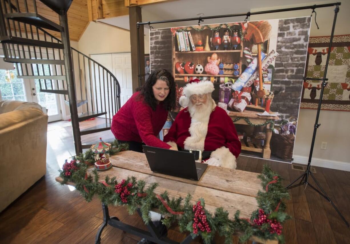 Kelly Stone, left, looks over WelcomeSanta.com with Jim Wood of Felida, also known as Santa Jim. WelcomeSanta.com gives kids a chance to connect with Santa over the internet. Below: Jim Wood’s Santa boots have a personalized touch.