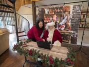 Kelly Stone, left, looks over WelcomeSanta.com with Jim Wood of Felida, also known as Santa Jim. WelcomeSanta.com gives kids a chance to connect with Santa over the internet. Below: Jim Wood’s Santa boots have a personalized touch.