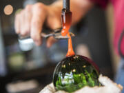 Greg Lueck uses super-heated glass to create a hook for a Christmas ornament.