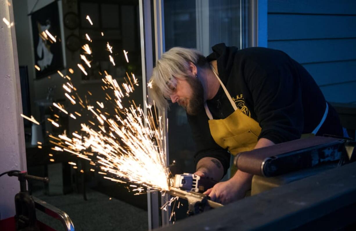 Ken Tucker works on shaping a dagger from a recycled sword that broke.