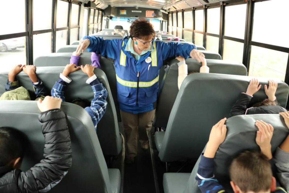 Battle Ground: Helen Peterson checks on Glenwood Heights Primary School students who are practicing earthquake safety.