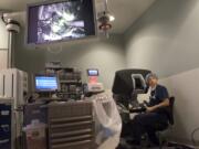 Dr. Scott Rushing, the medical director of PeaceHealth Southwest’s GYN/oncology services, glances up from his control console during his 1,000th robotic surgery, at PeaceHealth Southwest Medical Center in Vancouver. The console is similar to a flight simulator or video game. Rushing controls the surgeon robot with the console’s pedals and actuators, which are like joysticks.