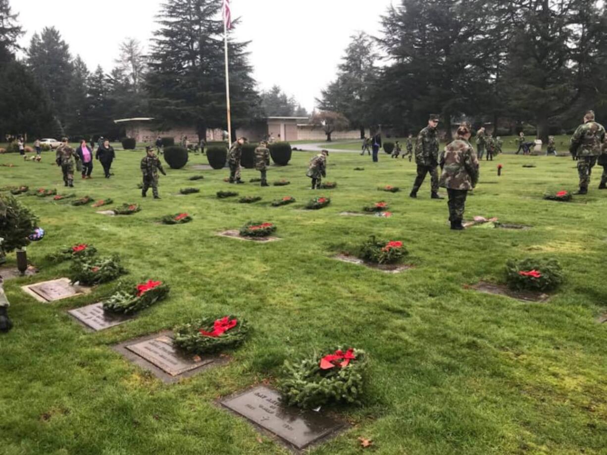 Members of the Lewis and Clark Young Marines place wreaths at the graves of veterans in the Evergreen Memorial Gardens during the 2017 Wreaths Across America ceremony. With around 70 members, Lewis and Clark Young Marines is among the largest and most active Young Marines chapters in the nation.