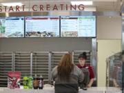 Tayler Smith of Papa Murphy’s helps customer Kimm Hulett of Portland on March 9, 2016, at Papa Murphy’s on East Mill Plain Boulevard.